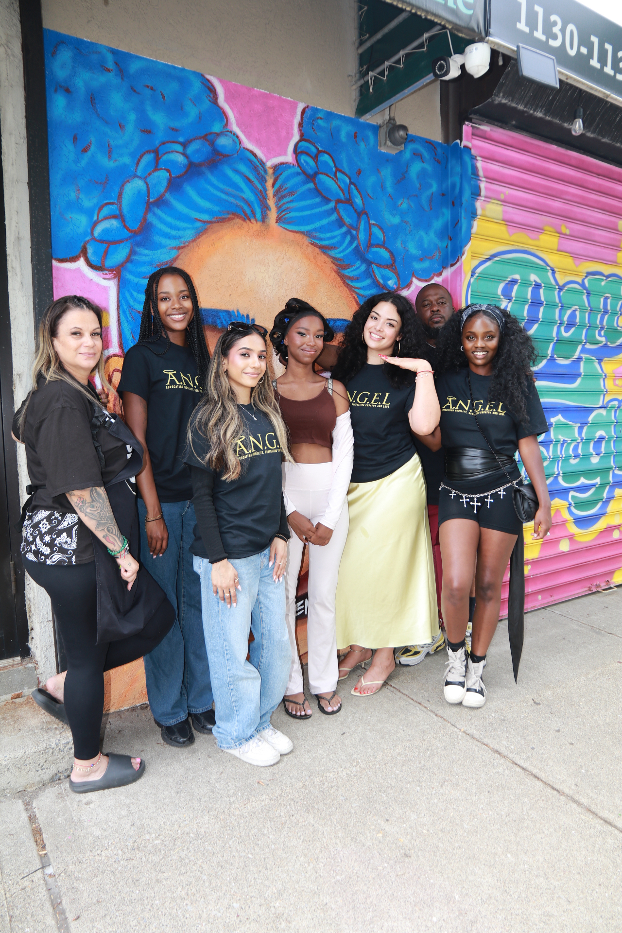 ANGEL team standing together in front of a vibrant mural